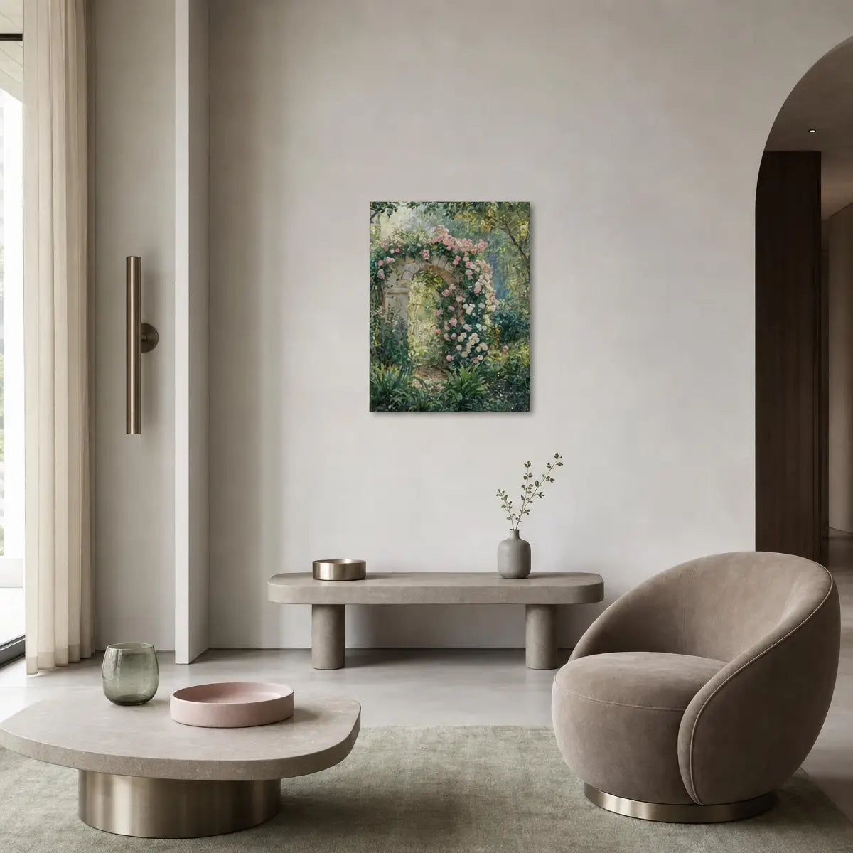 A framed vertical canvas print of an impressionist garden scene with green foliage and pink flowers, displayed on a light gray wall in a modern, minimalist living room with a beige armchair and low concrete bench.