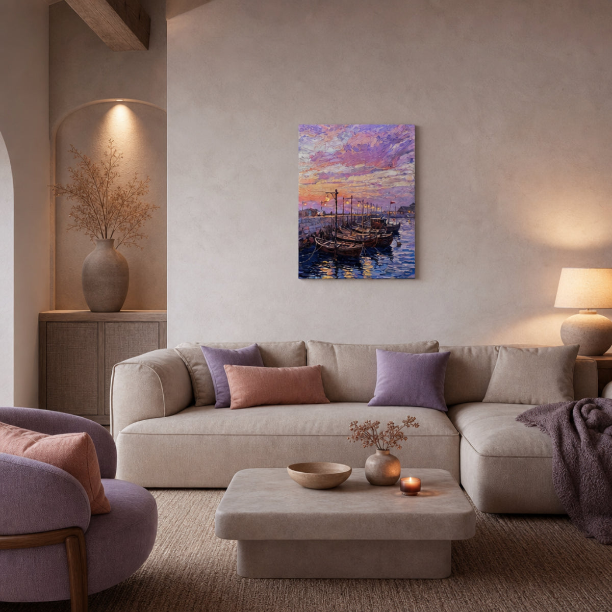 A square canvas art print depicting a colorful sunset harbor with sailboats, displayed on a beige wall in a modern, cozy living room setting with a sofa and pillows.