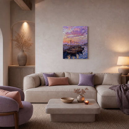 A square canvas art print depicting a colorful sunset harbor with sailboats, displayed on a beige wall in a modern, cozy living room setting with a sofa and pillows.