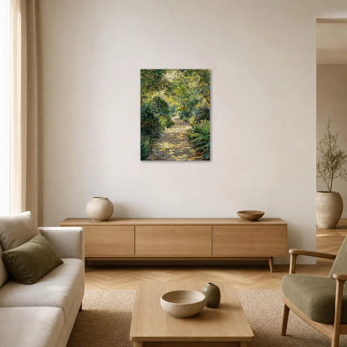 A framed vertical canvas print of a lush green forest path hangs on a beige wall in a modern, minimalist living room with light wood furniture.