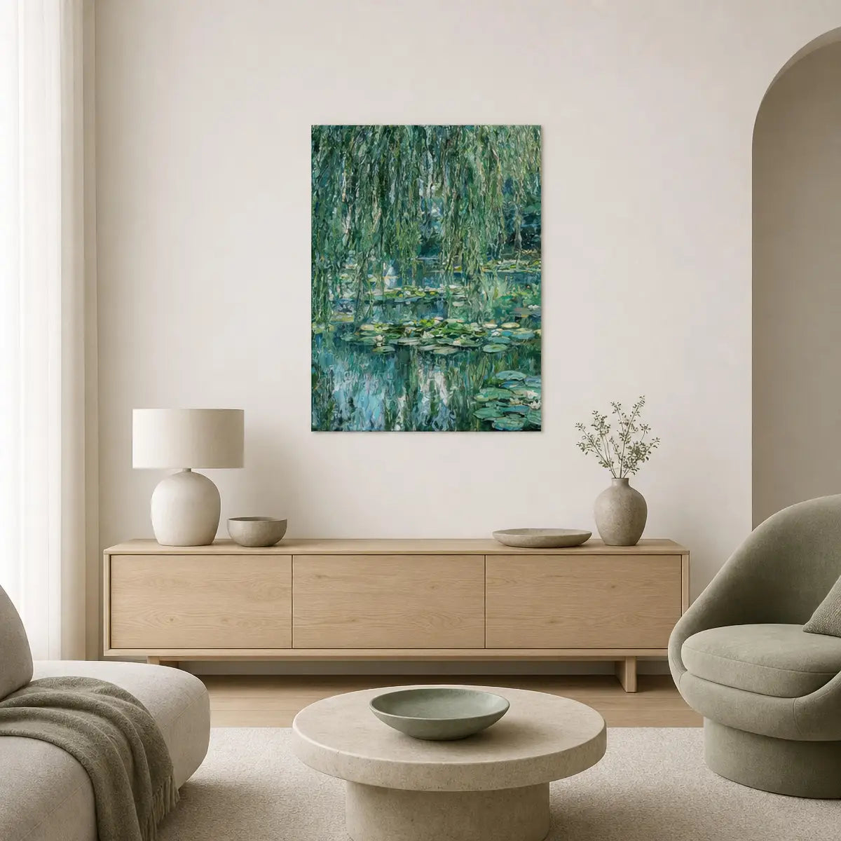 A framed vertical canvas print of a Monet-style water lily pond with green willow branches hanging on a light beige wall in a modern living room setting.