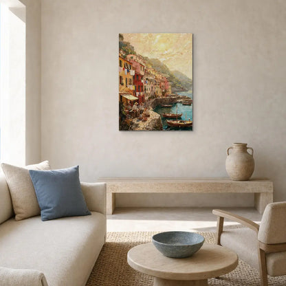 A vertical canvas print of a colorful coastal village harbor painting, styled on a textured beige wall in a modern living room setting above a low wooden bench and sofa.