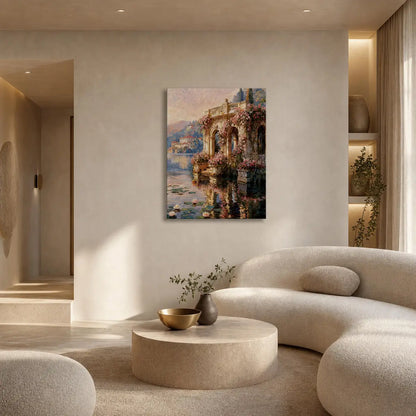 A vertical canvas art print depicting a romantic Mediterranean or European villa by the water, styled in a modern, warm-toned living room above a curved beige sofa.