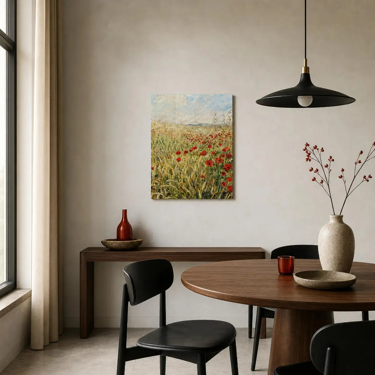A framed-style wall art print depicting a field of red poppies hangs on a beige wall in a modern dining room setting with a wooden table, black chairs, and a black pendant light.