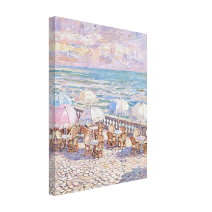 A vertical canvas wall art print depicting an impressionist seaside cafe scene with pastel umbrellas, tables, and a rocky beach under a cloudy sky, shown at an angle on a white background.
